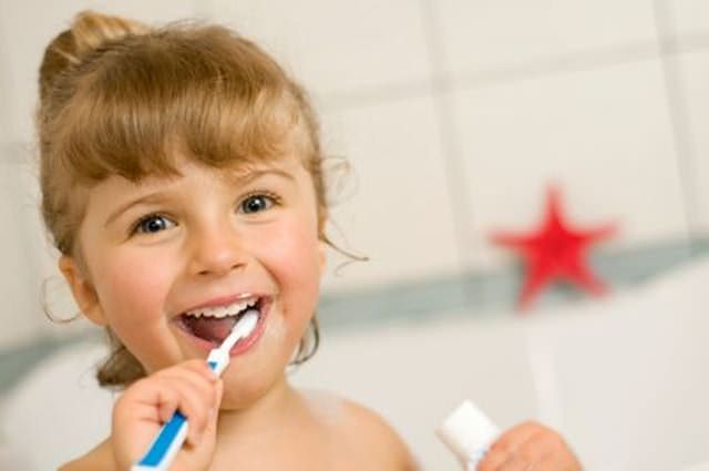 Blondwłosa dziewczynka myje ząbki