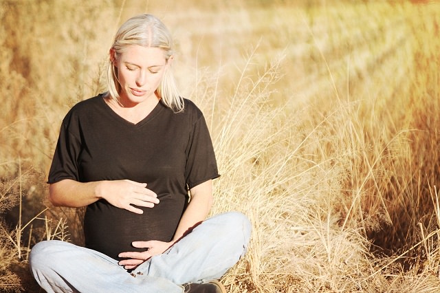 Kobieta w ciąży siedzi na słońcu