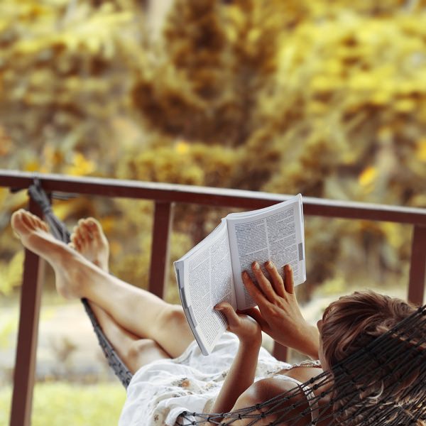 Kobieta czyta książkę na hamaku